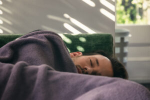 A caucasian man taking an afternoon nap on couch at home
